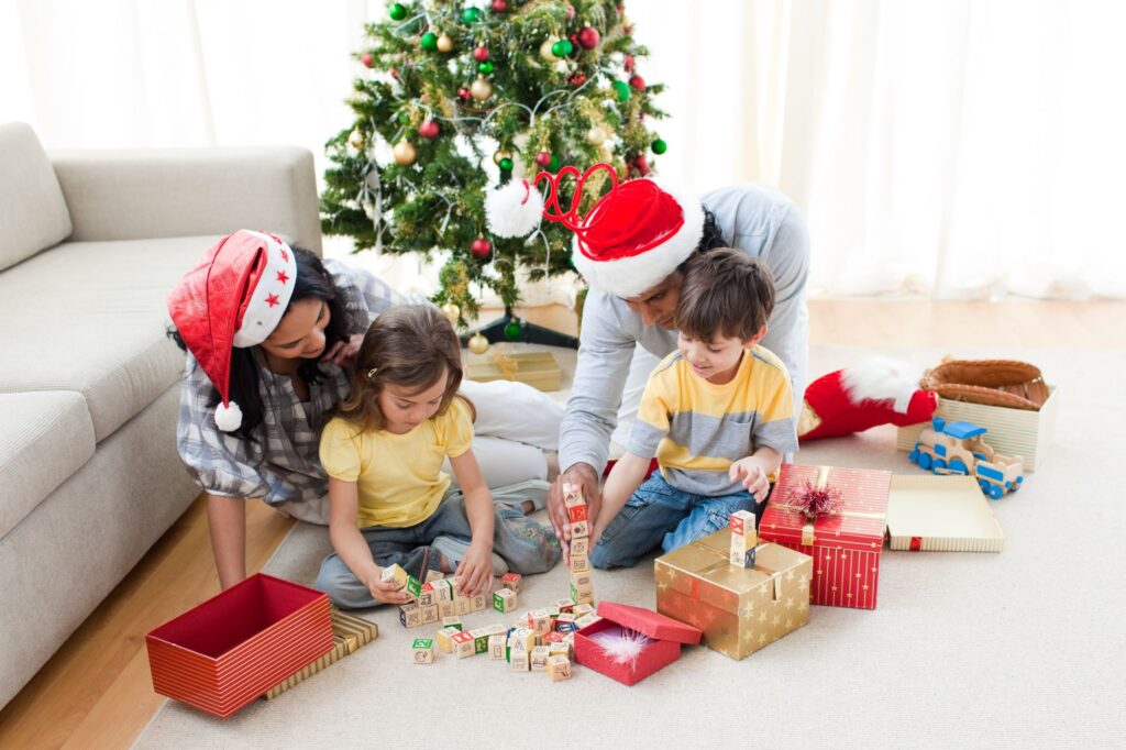 A happy family in the living room surrounded by Christmas presents.