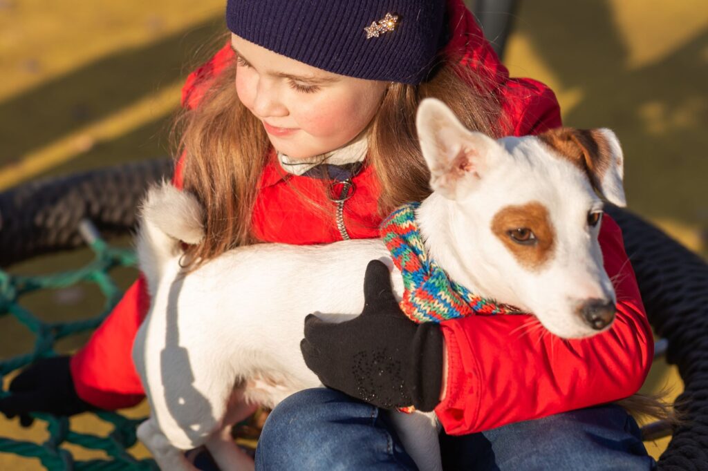 A child and her dog in the park.